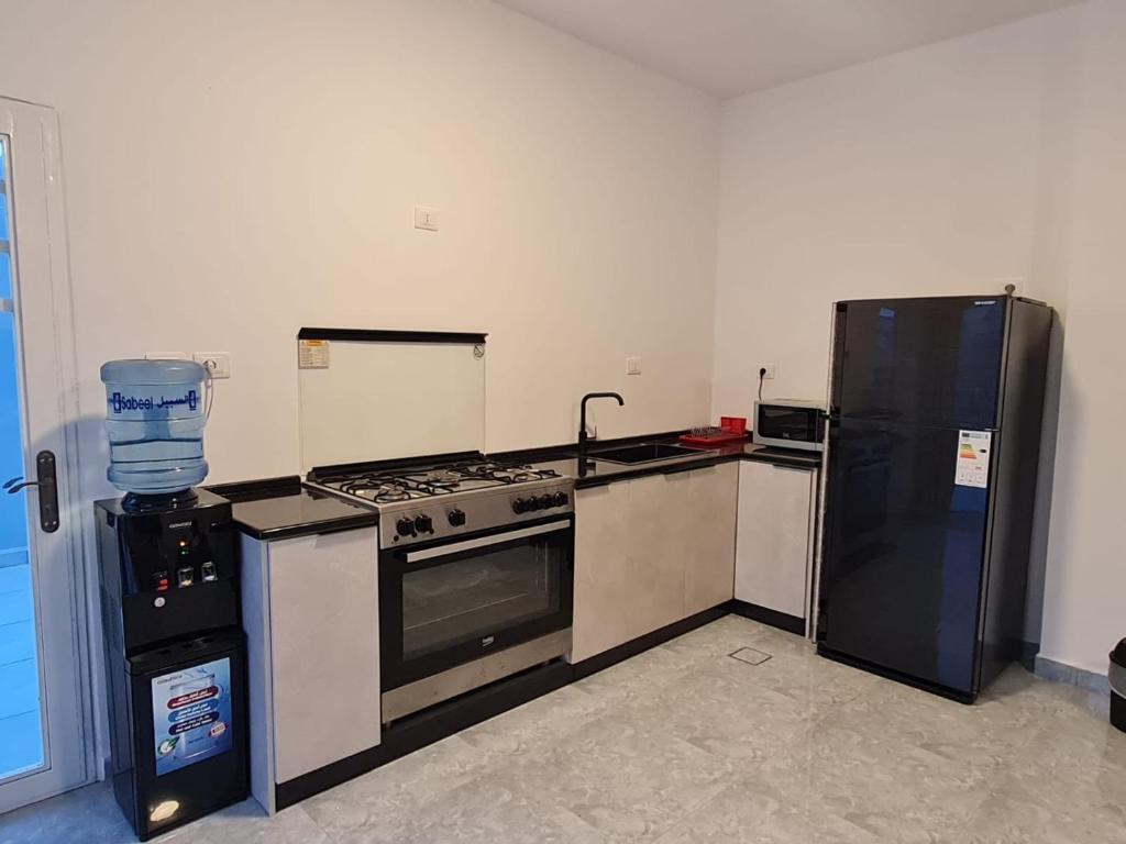 a kitchen with a stove and a refrigerator at Jimi Chalet in Al Kafrayn