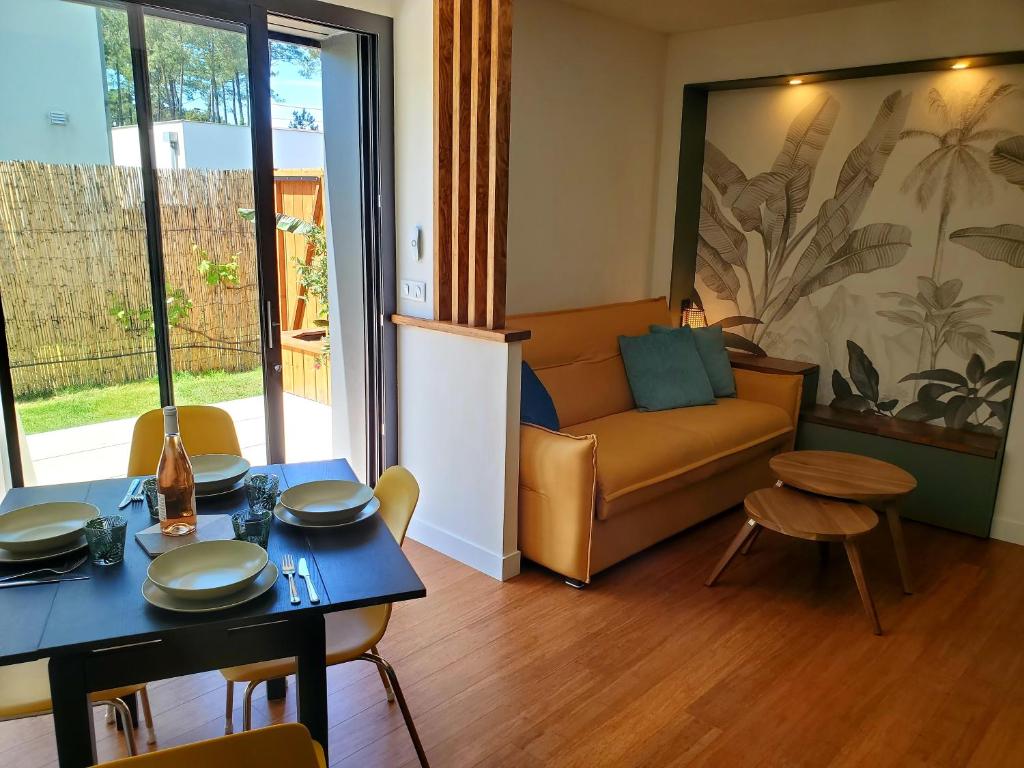 uma sala de estar com um sofá e uma mesa em Brand new surf lodge at the end of golf em Soorts-Hossegor