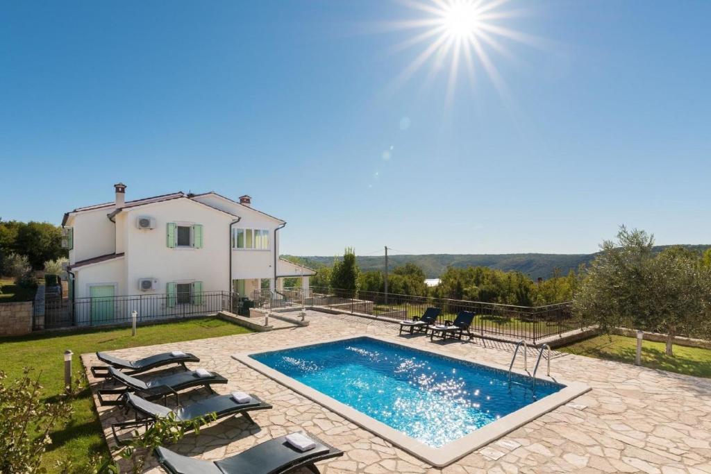 een villa met een zwembad en een huis bij Ferienhaus mit Privatpool für 8 Personen ca 210 qm in Trget, Istrien Bucht von Raša in Trget