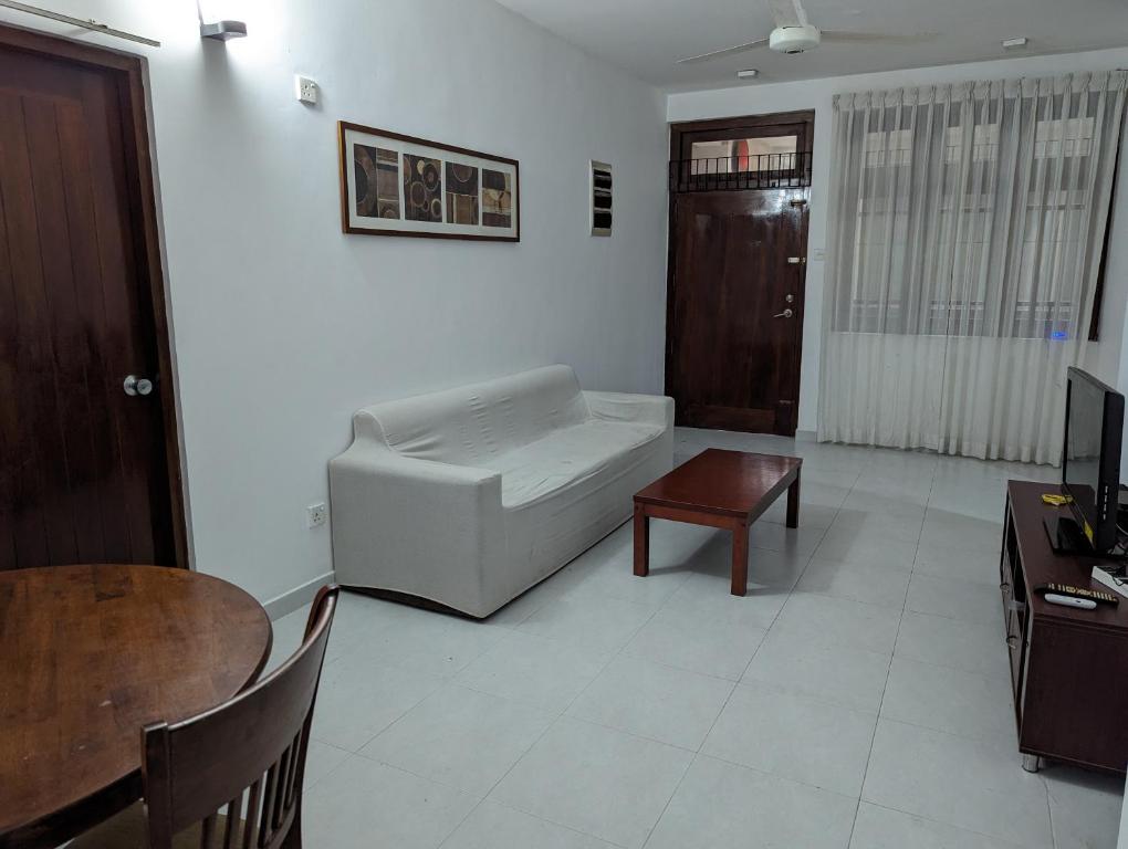 uma sala de estar com um sofá e uma mesa em Homestay relax and enjoy em Sri Jayewardenepur- Kotte