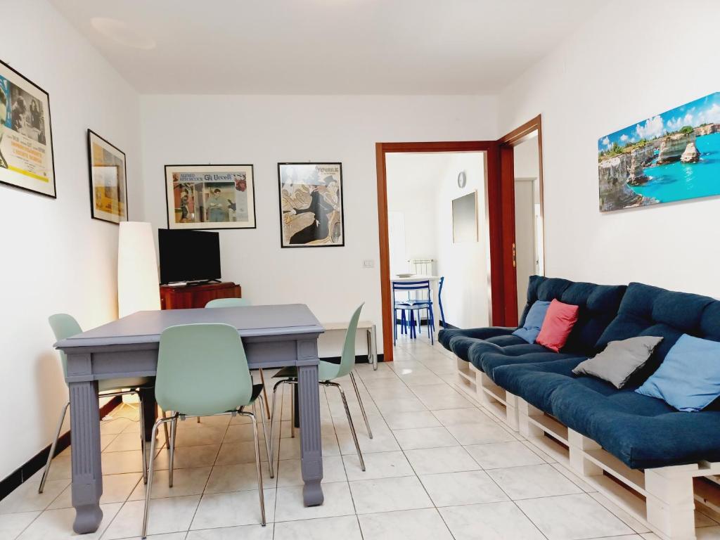 ein Wohnzimmer mit einem blauen Sofa und einem Tisch in der Unterkunft Mansardato 20 mt dal mare Albissola Marina in Albissola Marina