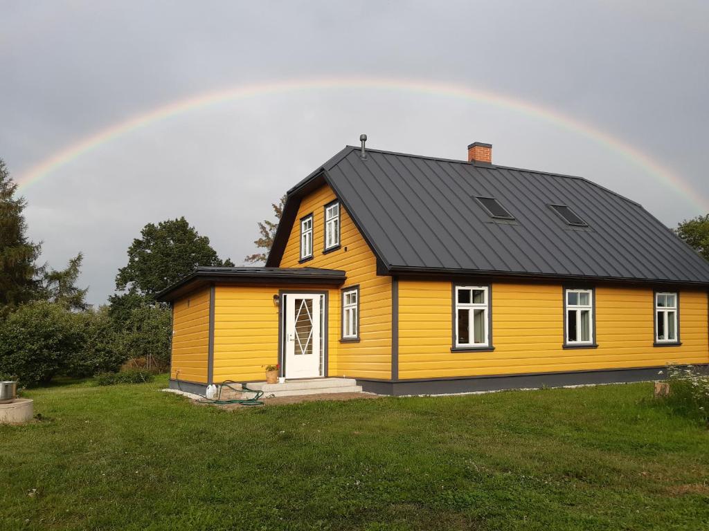 a yellow house with a black roof with a rainbow at Privacy within city limits in Tartu