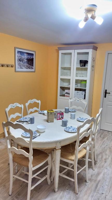 une salle à manger avec une table et des chaises blanches dans l'établissement La marmotte, à Entremont