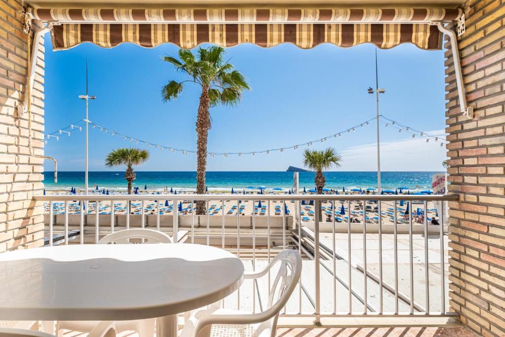 a balcony with a table and chairs and the beach at Los Ranchos 1-3 Apartment Levante Beach in Benidorm