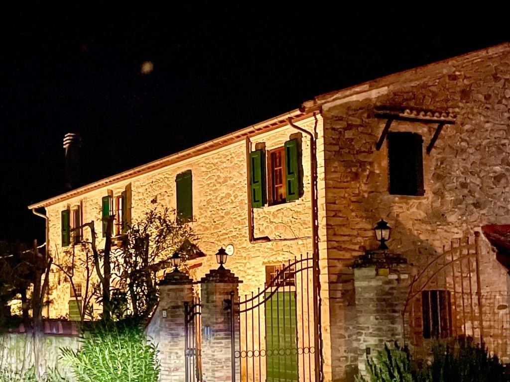 ein Steingebäude mit einem Zaun davor in der Unterkunft Podere Ostoncino in Chianni
