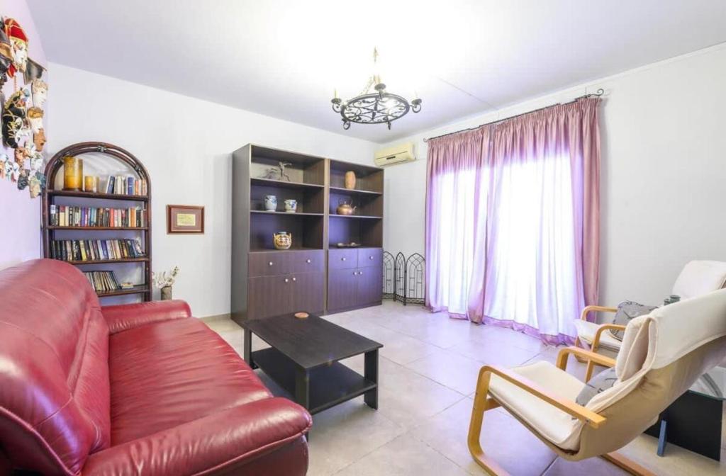 a living room with a red couch and a table at Crete Idyllic 1Bd Apt with Patio Garden in Kavrokhórion
