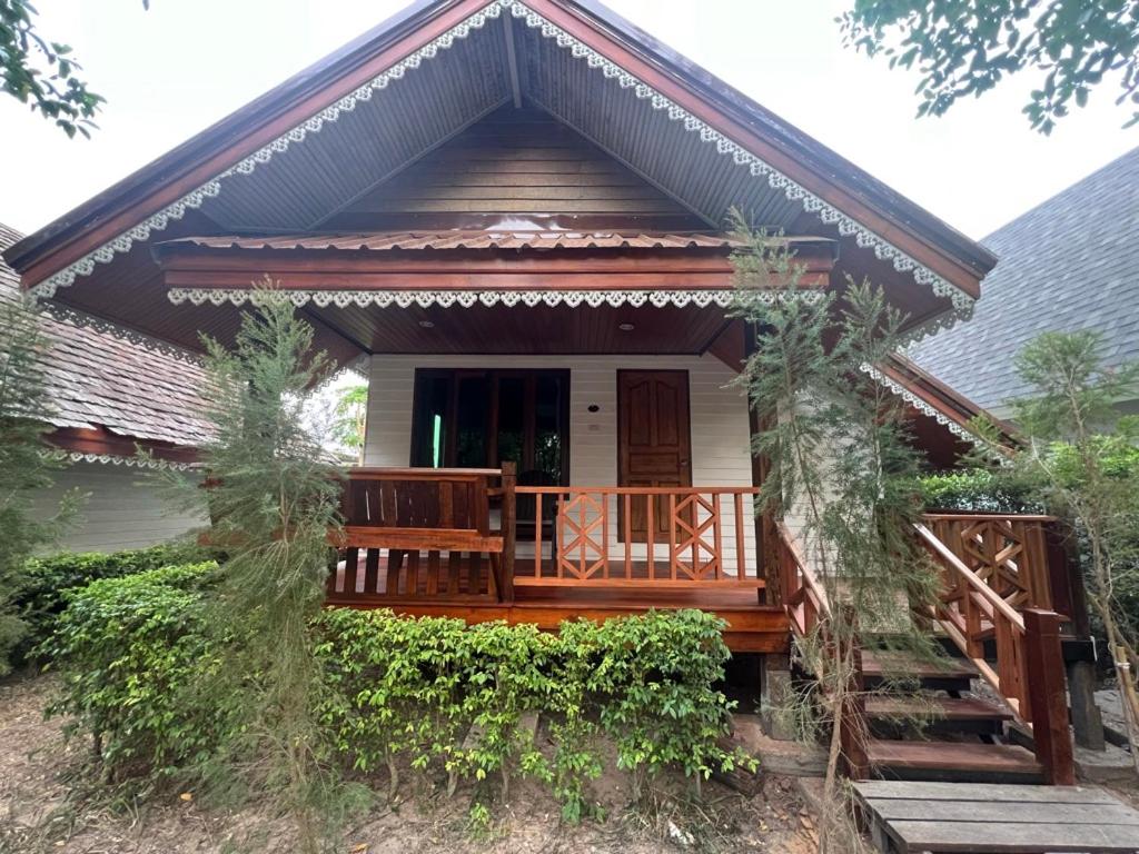 Sirilagoona Home Resort في Nong Prue: منزل صغير مع شرفة خشبية كبيرة