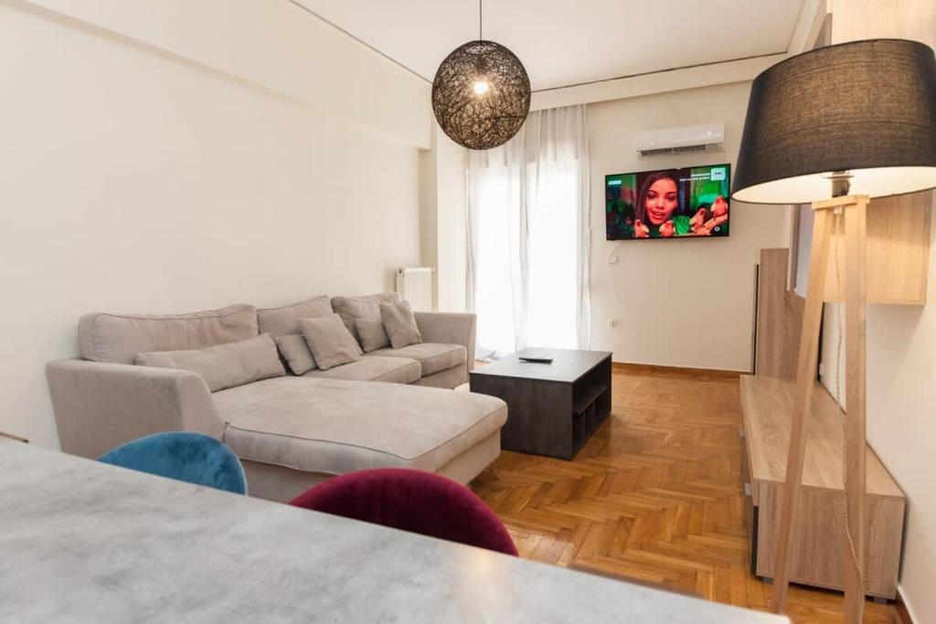 a living room with a couch and a tv at Luxury Pireas Stay New 2BR Urban Escape in Piraeus