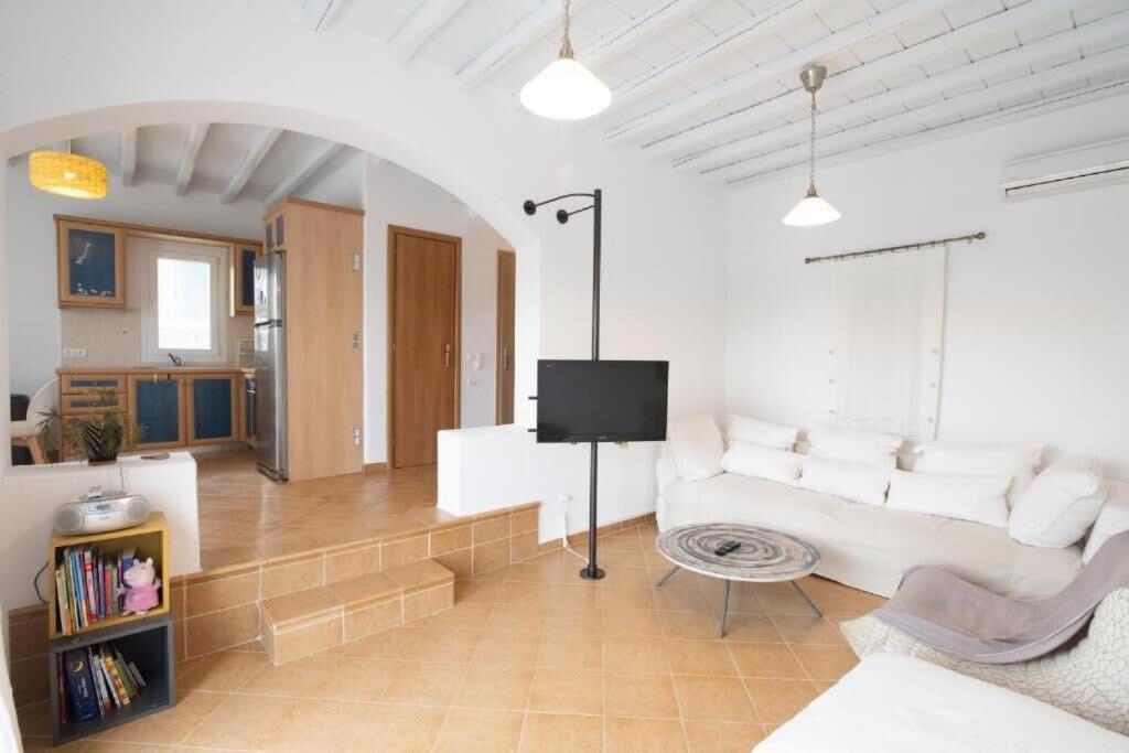 un soggiorno con divano bianco e TV di Dreamscape Cozy 3-Bedroom Mykonos Hideaway ad Áno Merá