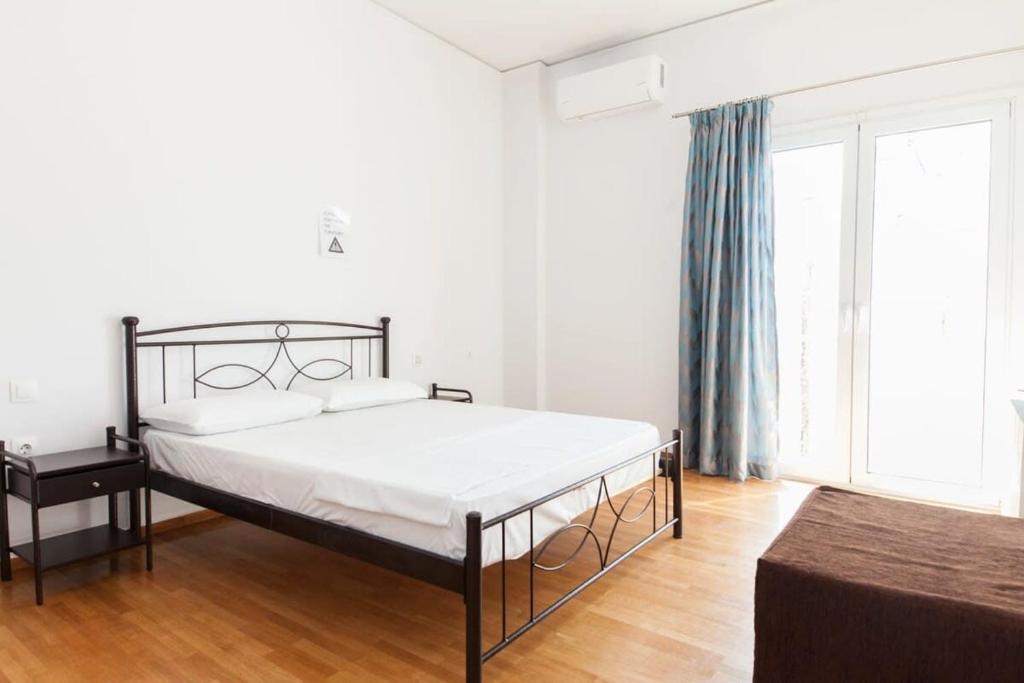 een slaapkamer met een bed en een groot raam bij Brand new 1 Bd Apt in Kolonaki in Athene