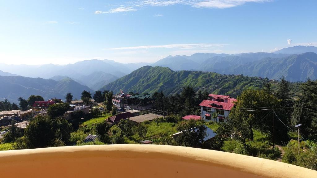 a view of a mountain village with mountains in the background at Naldehra House in Shimla
