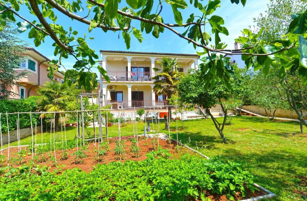 um jardim em frente a uma casa em Ferienwohnung für 3 Personen ca 32 qm in Poreč, Istrien Istrische Riviera em Porec