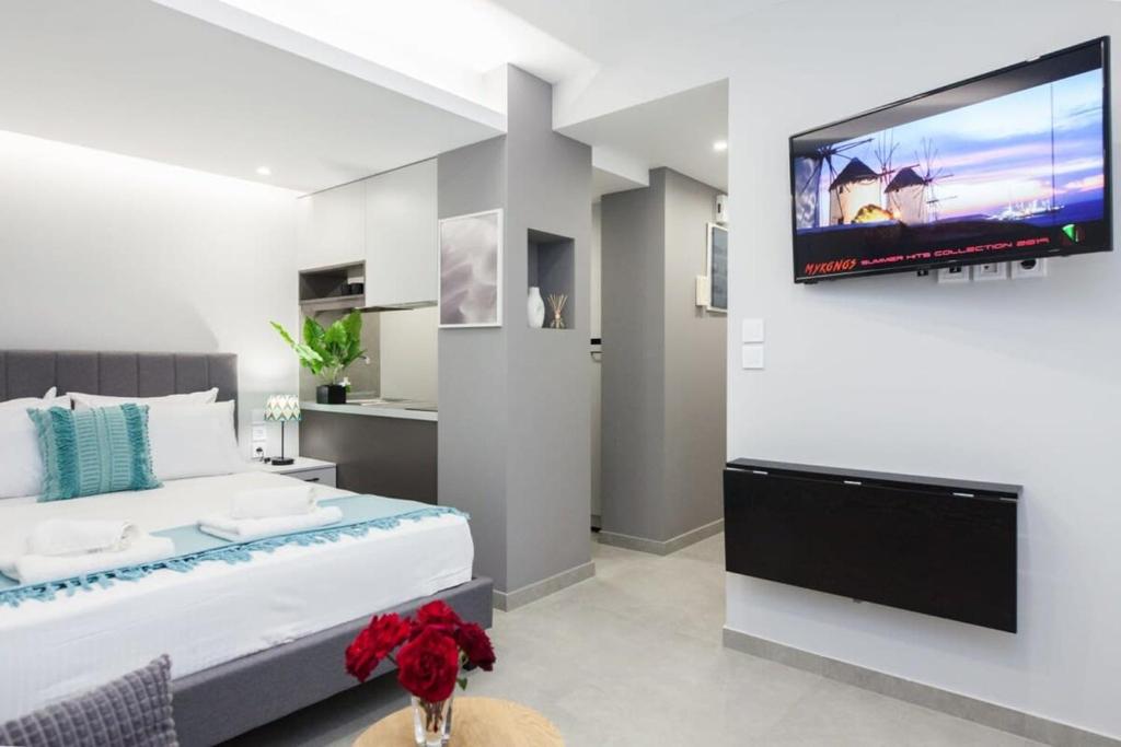 a bedroom with a large bed and a flat screen tv at Brand New Modern Studio Close to Hilton District in Athens