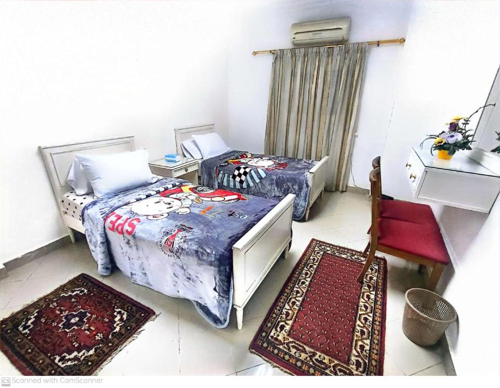een kamer met twee bedden en twee tapijten erin bij ابراج المهندسين المعادي كورنيش بجوار مستشفي السلام الدولي in Caïro