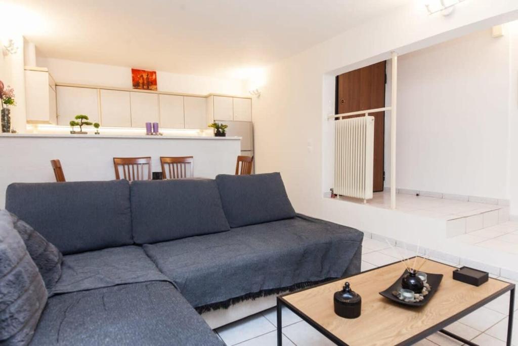 uma sala de estar com um sofá azul e uma mesa em Delightful Modern 1 Bedroom Apartment in Kallithea em Atenas