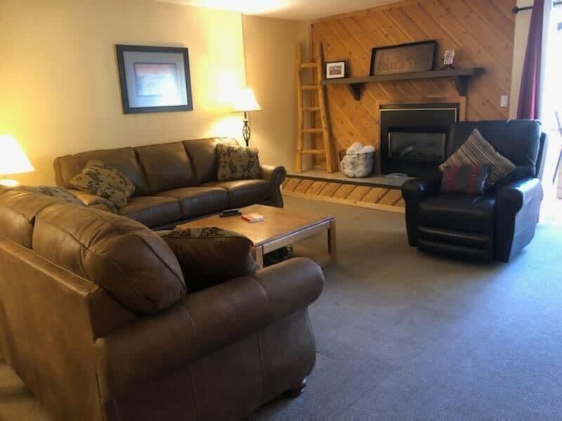 uma sala de estar com um sofá, uma cadeira e uma lareira em Downtown Chalet Close to Main St with Pool and Hot Tub em Breckenridge