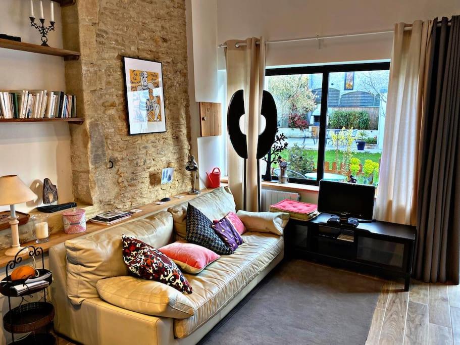 - un salon avec un canapé et des oreillers dans l'établissement Le Paradis - 2 Chambres, à Douvres-la-Délivrande