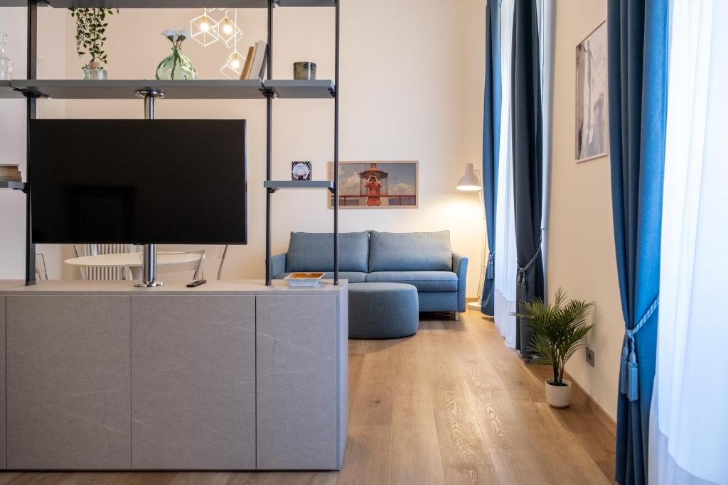 uma sala de estar com televisão e um sofá azul em EVE Home Collection - City Center em Trieste