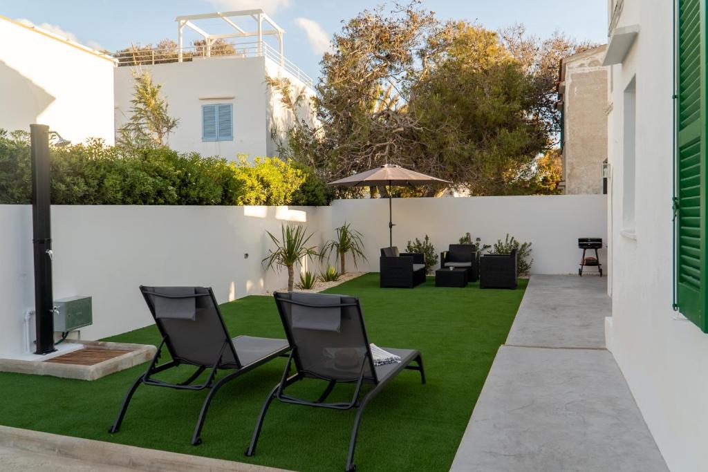 a garden with chairs and a lawn at Apartamento Villa Irene Menorca in Cala Santandria