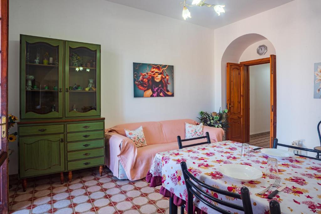 ein Wohnzimmer mit Tisch und Couch in der Unterkunft Casa Arianna, apartment a few steps from the sea in Marina di Mancaversa