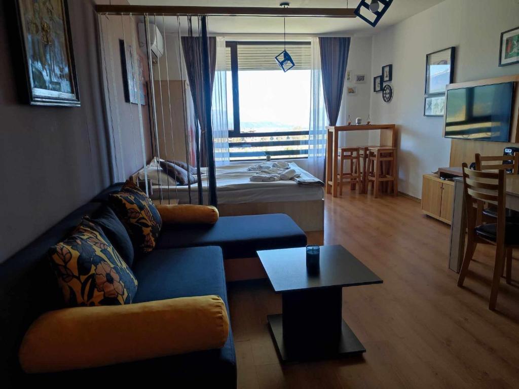 a living room with a couch and a table at F307 Studio Aspen Golf Resort Bansko in Bansko