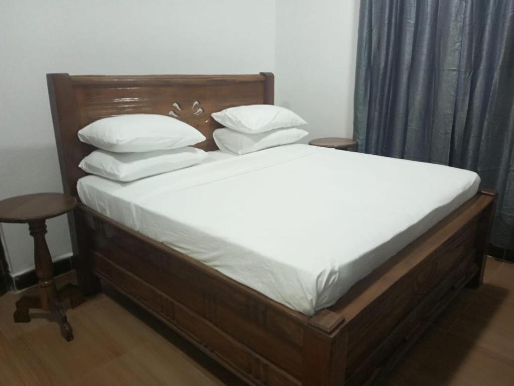 uma cama com lençóis brancos e almofadas num quarto em PM Lodge and Restaurent em Matemwe
