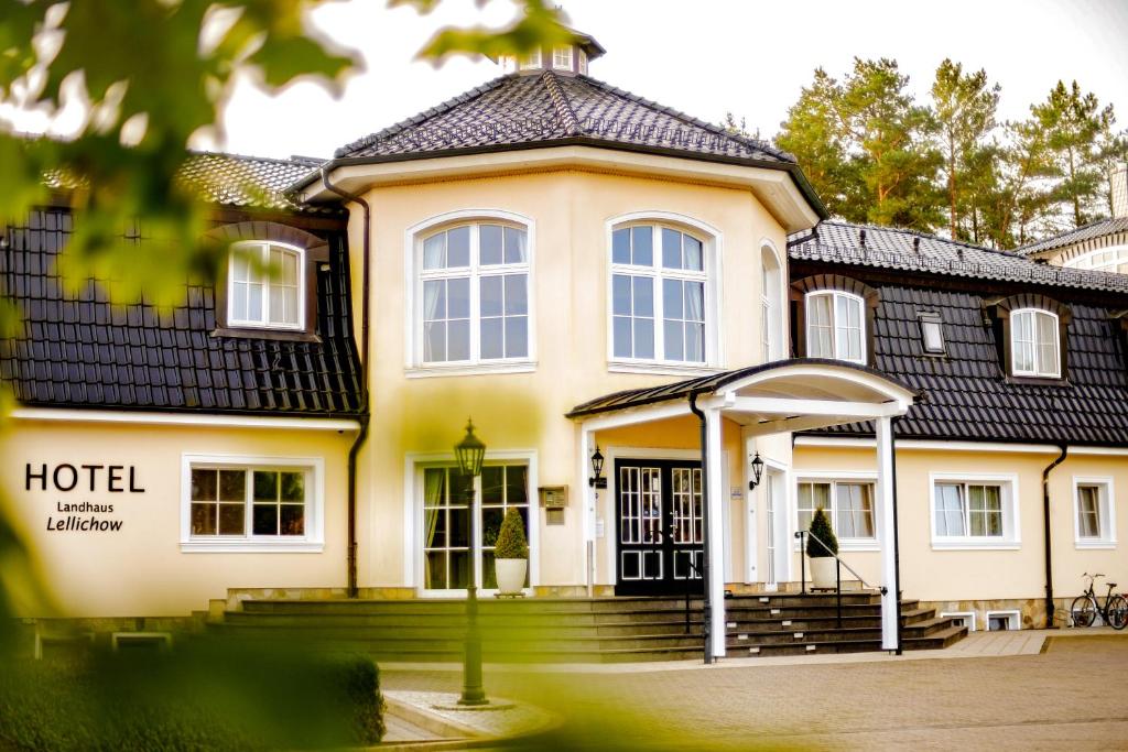 une grande maison jaune avec un toit noir dans l'établissement Landhaus Lellichow, à Lellichow
