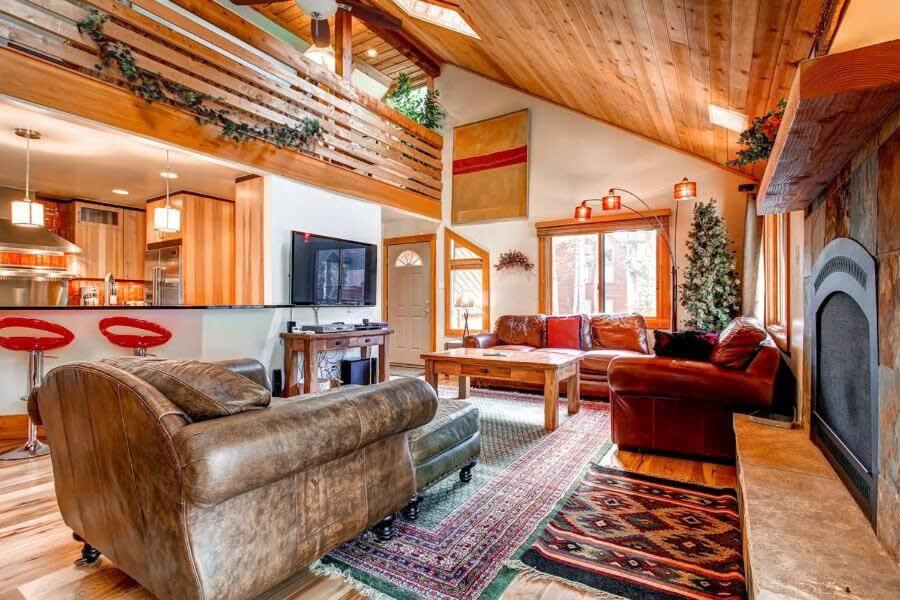 a living room with a couch and a fireplace at 5BR Ski in Out Mountain Getaway with Hot Tub and Views in Breckenridge