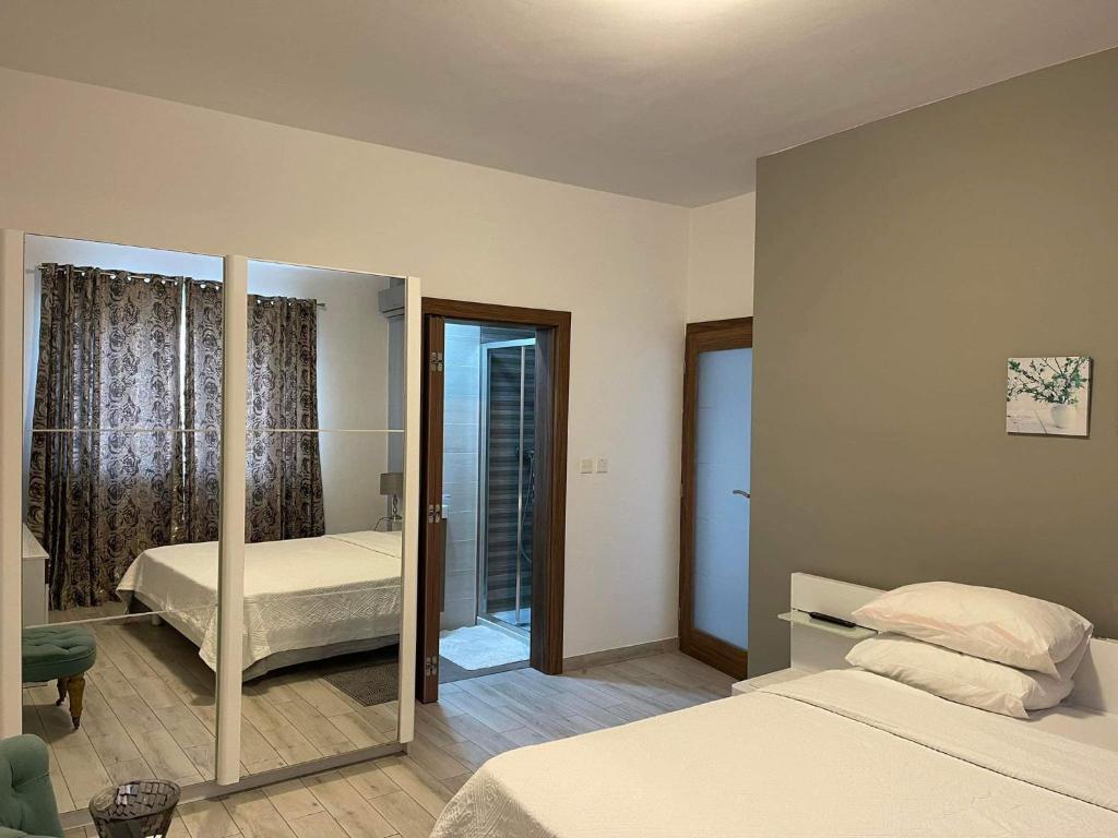 een slaapkamer met 2 bedden en een spiegel bij 74 temple point 3 bedroom APT in Marsaxlokk