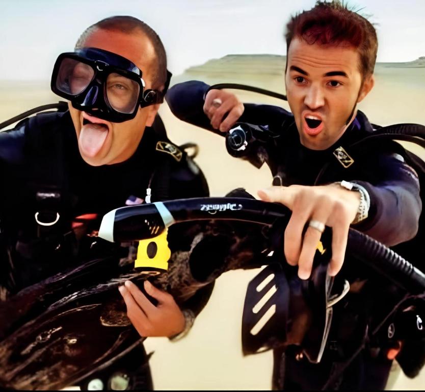 two men dressed in diving gear looking at a camera at Mayorca scuba diving dakhla in Dakhla