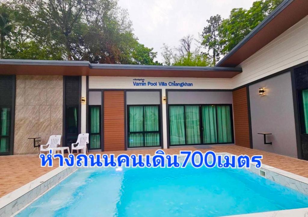 une maison avec une piscine en face de celle-ci dans l'établissement Vamin Poolvilla Chiangkhan Loei วามินทร์พูลวิลล่า เชียงคาน เลย - วามินทร์ รีสอร์ท, à Chiang Khan