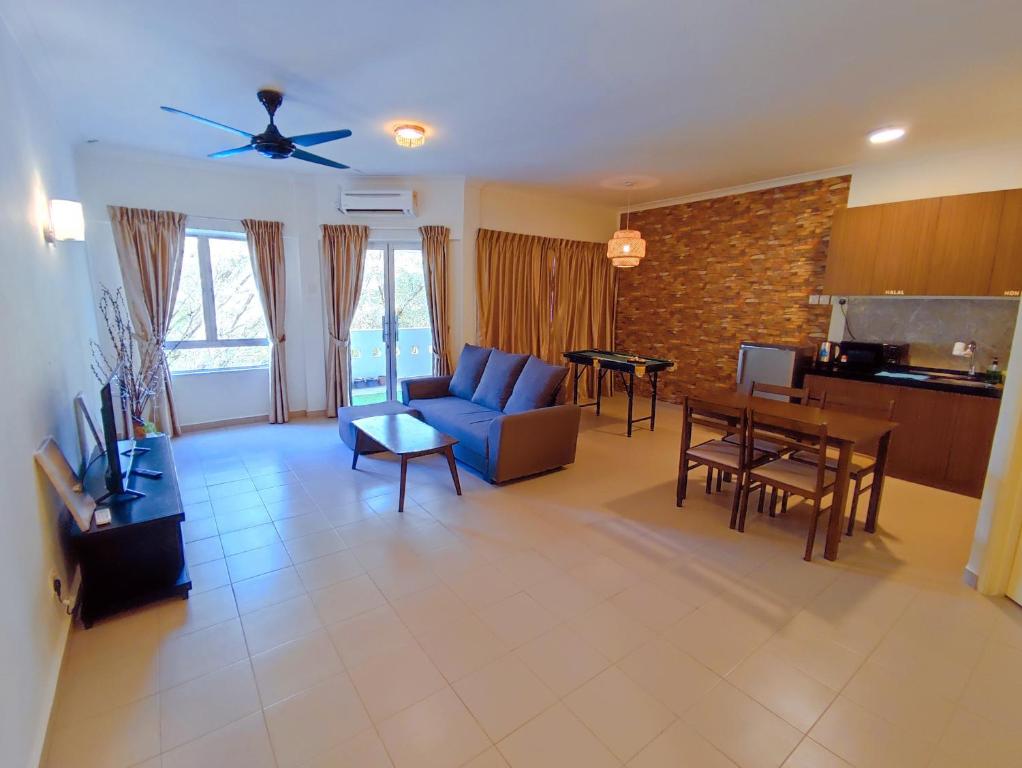 uma sala de estar com um sofá azul e uma mesa em Balini Home Tiara Desaru em Desaru