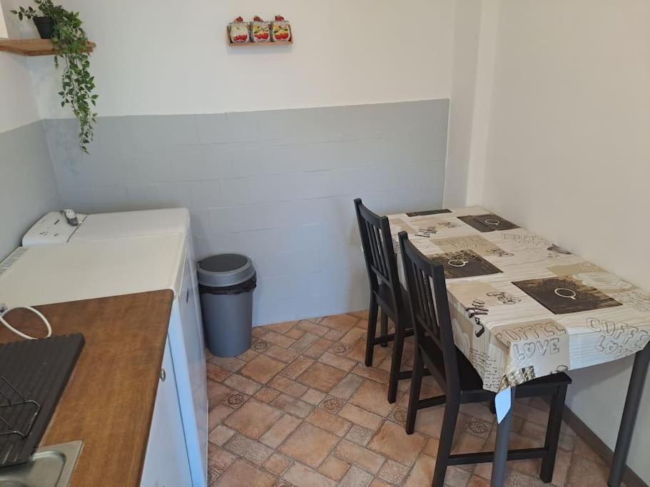 a kitchen with a table and chairs in a room at Andi Apartment Szeged Center in Szeged