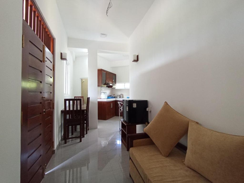 een woonkamer met een bank en een keuken bij skyline villa in Adawikanda