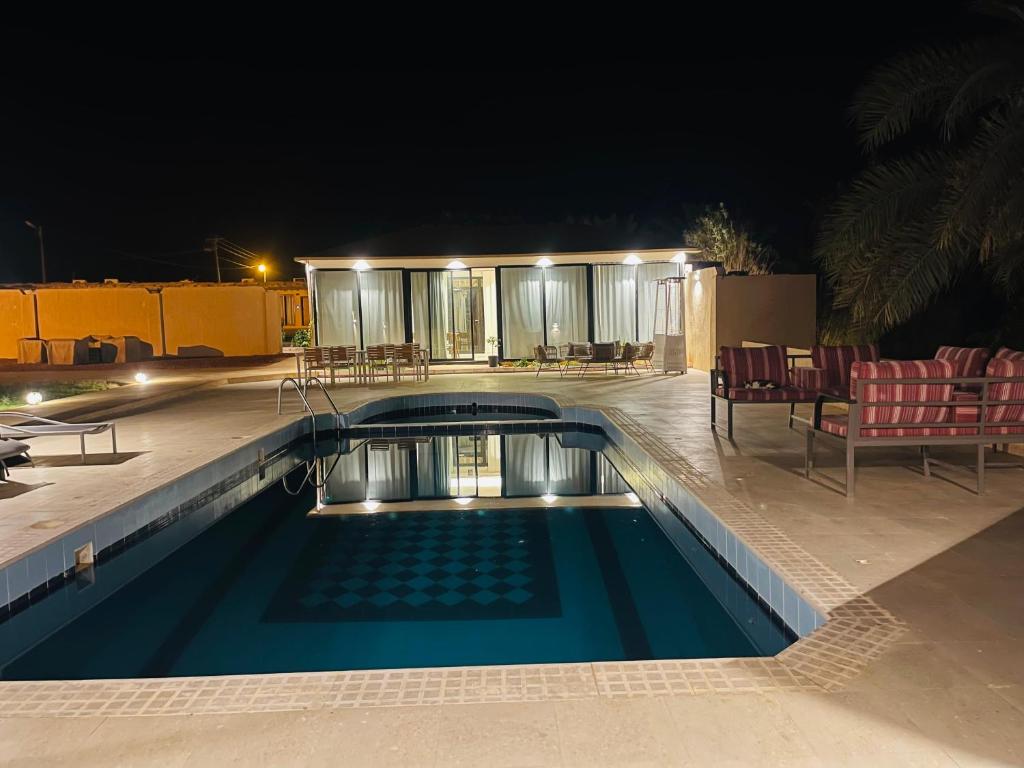 una piscina en medio de una casa por la noche en سيال 1, en Al Ula