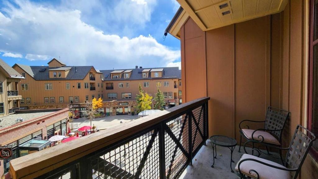 a balcony with chairs and a view of a building at Main St Station Condo with Hot Tub and Parking in Breckenridge
