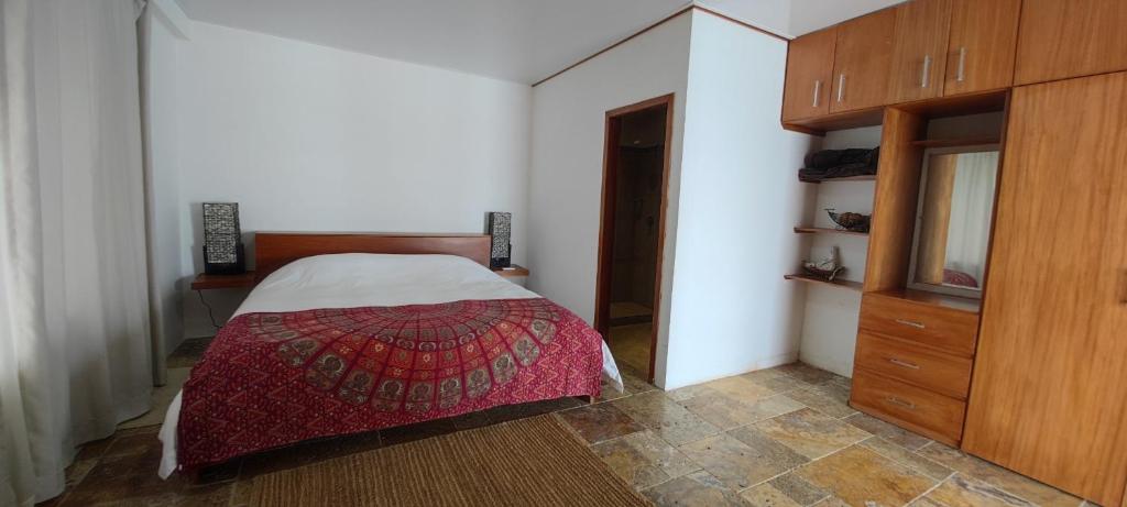 1 dormitorio con 1 cama y armario de madera en VILLA FLOREANA, en Puerto Velasco Ibarra