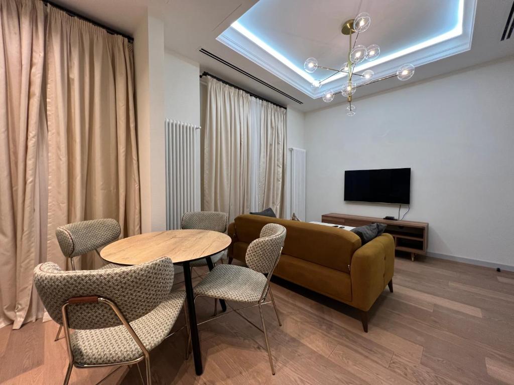 un soggiorno con divano, tavolo e sedie di ARP_apartments a Baku
