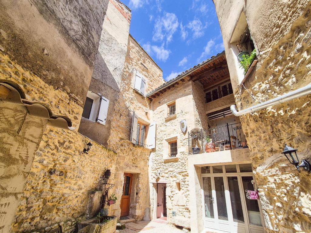 Une allée dans une vieille ville avec des bâtiments en pierre dans l'établissement Au Lys rose, à LʼIsle-sur-la-Sorgue