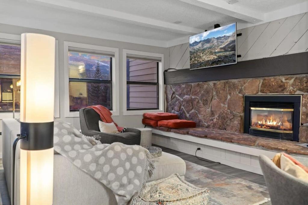 a living room with a fireplace and a tv at Chic 2BDR Downtown Condo Walk Everywhere in Breckenridge