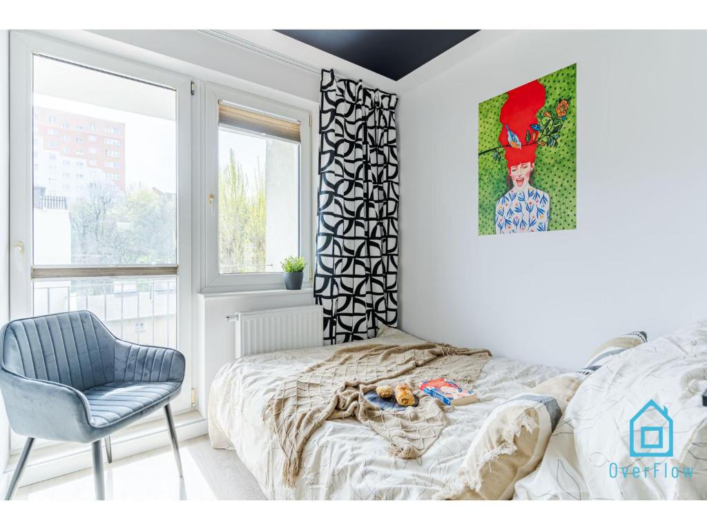 um quarto com uma cama, uma cadeira e uma fotografia em Lavender Room em Gdańsk
