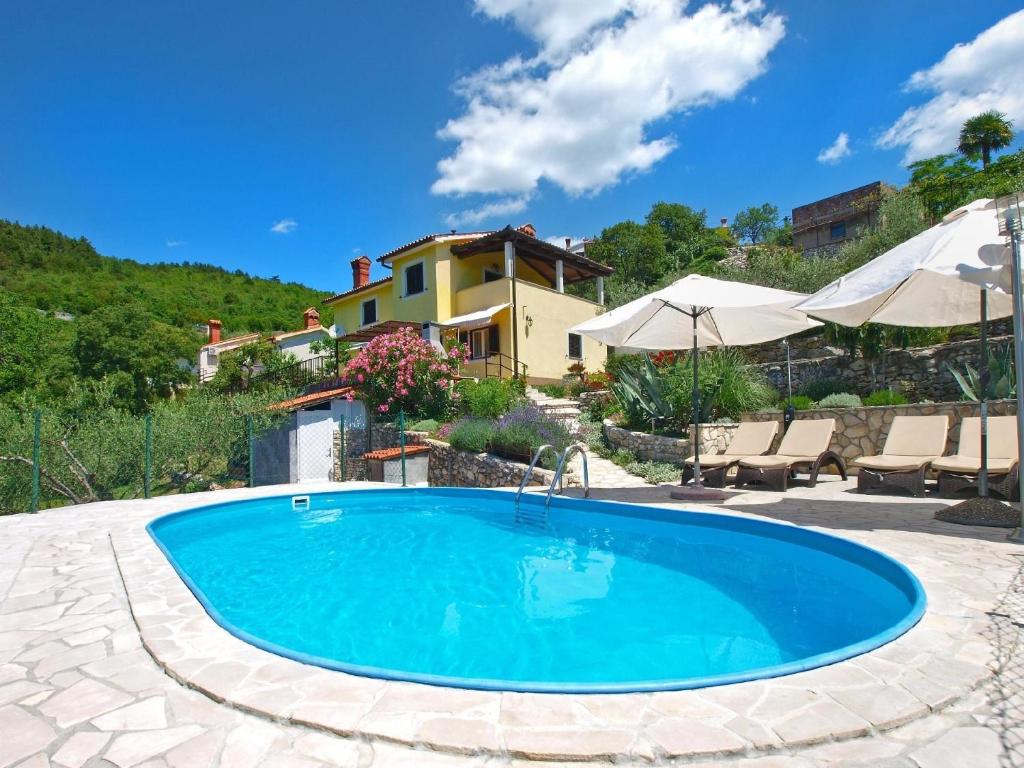 a swimming pool in a yard with a house at Ferienhaus mit Privatpool für 6 Personen ca 85 qm in Rabac, Istrien Bucht von Rabac in Rabac