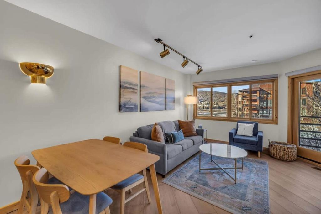 a living room with a table and a couch at Steps From Ski Lift Garage Parking Included in Park City