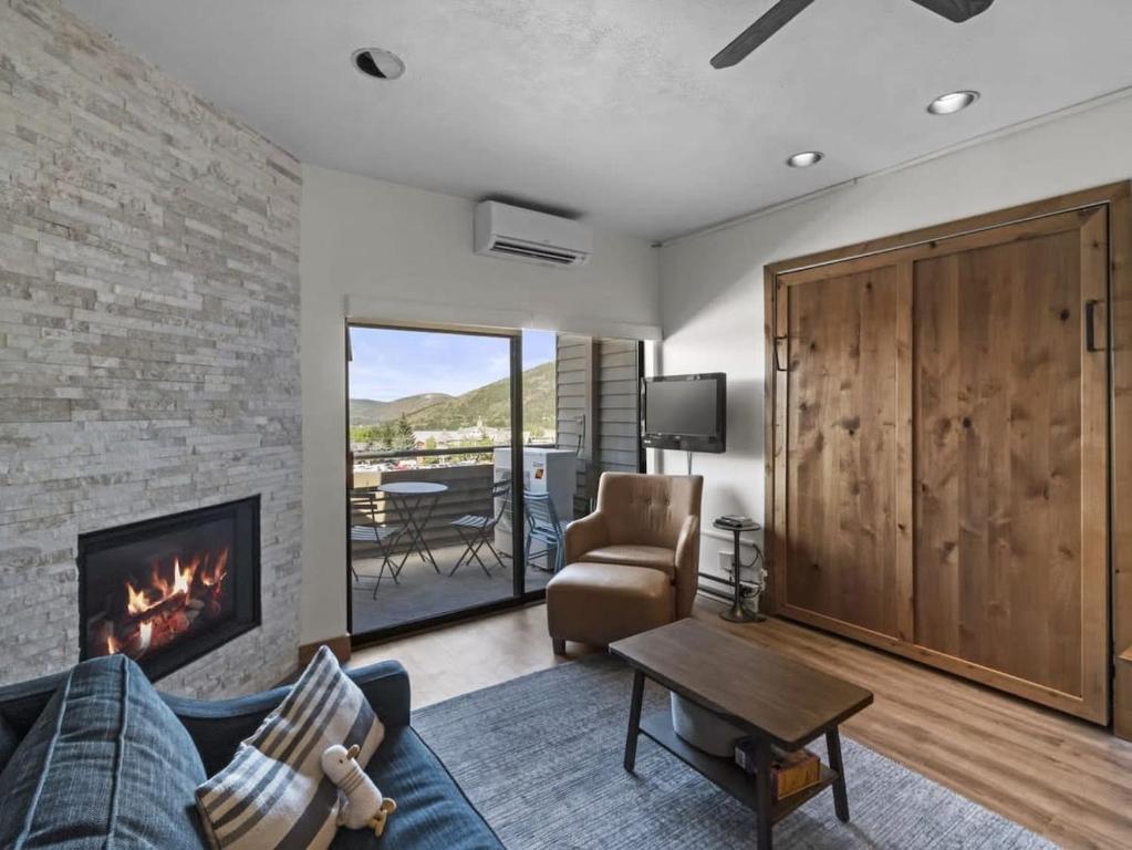 uma sala de estar com um sofá e uma lareira em Cozy Ski In Ski Out Studio with Hot Tub Access em Park City