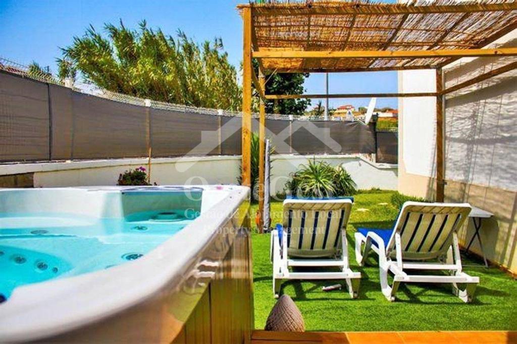 eine Badewanne im Garten mit zwei Stühlen in der Unterkunft Ferienwohnung für 6 Personen ca 30 m in Lourinha, Regio Centro in Lourinhã