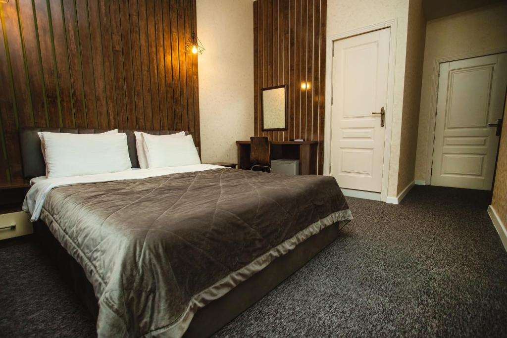 una camera d'albergo con un grande letto e una porta di Moss Art Boutique Hotel a Baku