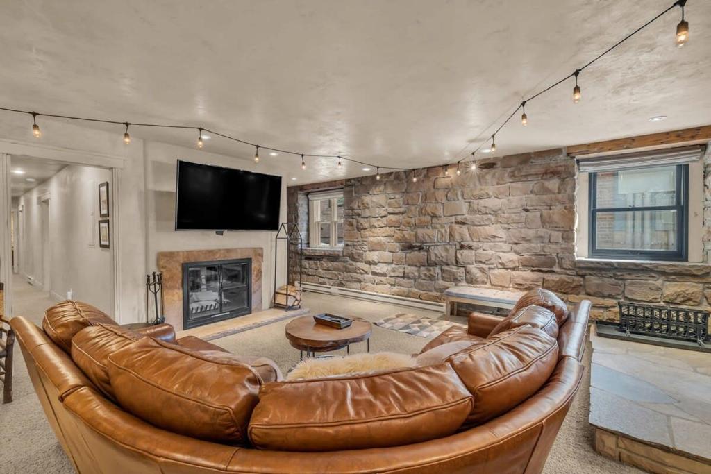 a living room with a leather couch and a fireplace at Rustic 2BR Steps from Main St in Park City
