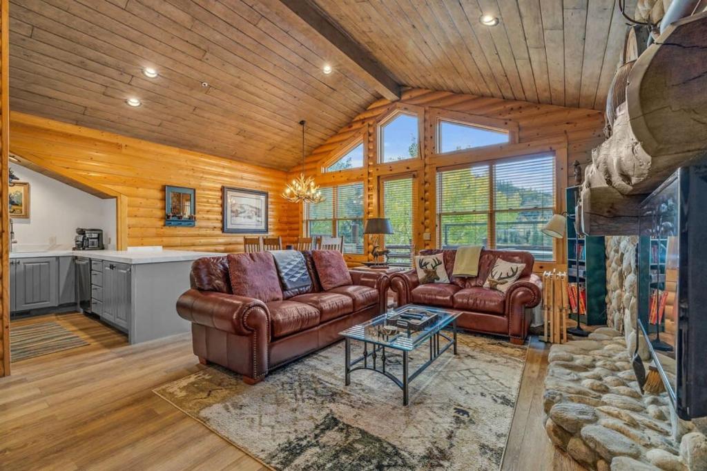 a living room with leather furniture and a fireplace at Luxurious 2BDR in Deer Valley with Hot Tub in Park City