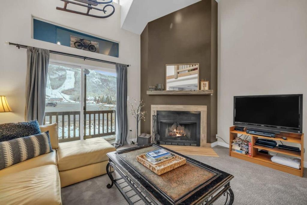 a living room with a couch and a fireplace at 2BD Condo with Ski Run Views and Hot Tub Access in Park City