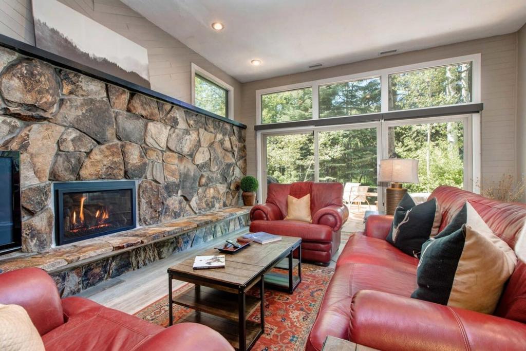 een woonkamer met banken en een stenen open haard bij Ski in and out 4BDR Townhome with Aspen Views and Hot Tub in Park City